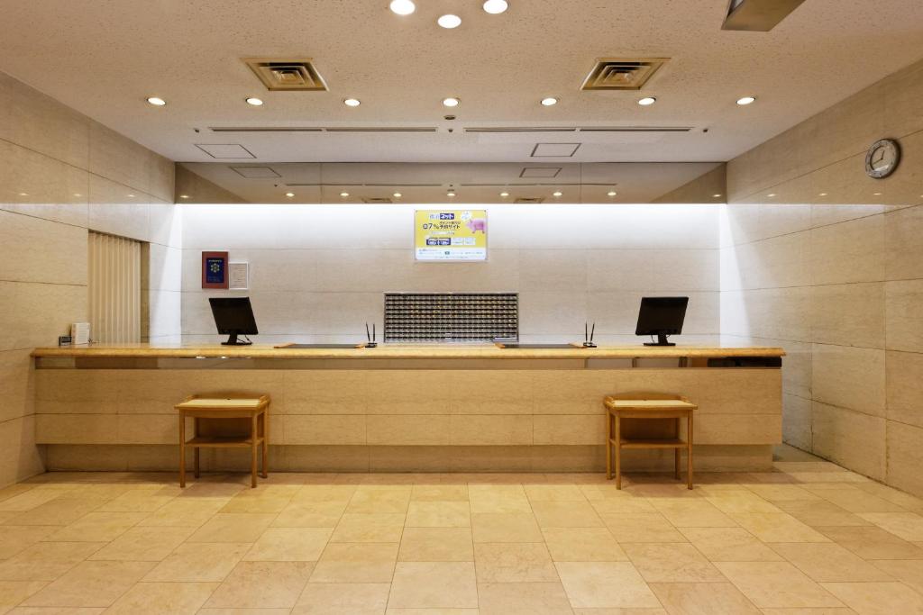 une salle d'attente avec deux chaises et un comptoir dans un bâtiment dans l'établissement Kagoshima Washington Hotel Plaza, à Kagoshima