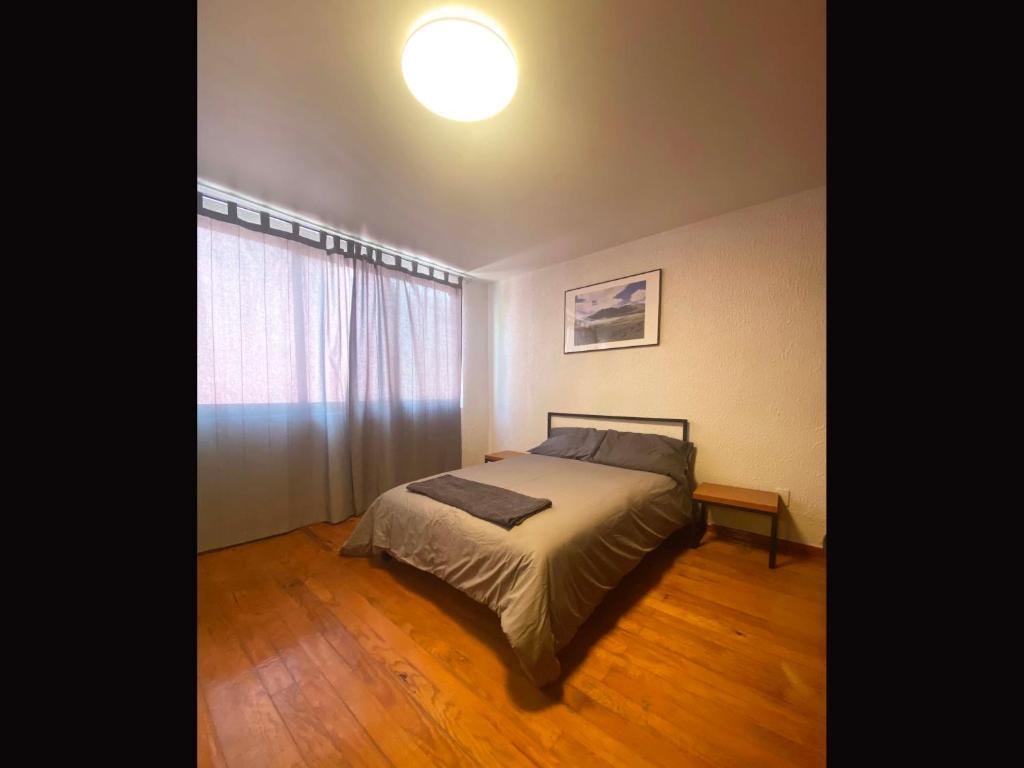 ein Schlafzimmer mit einem Bett und einem großen Fenster in der Unterkunft Cozy and private Suite in CDMX 5 in Mexiko-Stadt