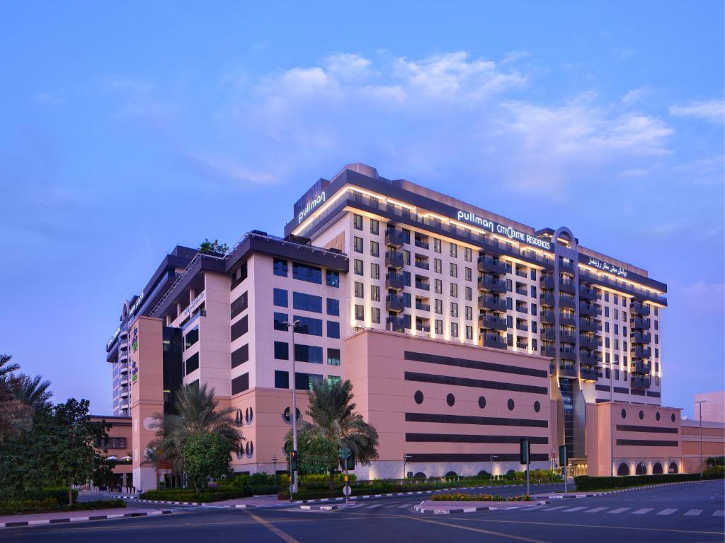 a large building with a large clock on the side of it at Pullman Dubai Creek City Centre Residences in Dubai