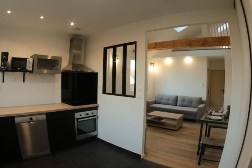 cocina y sala de estar con sofá en Logement indépendant appartement T2 bis style loft, en La Vraie-Croix