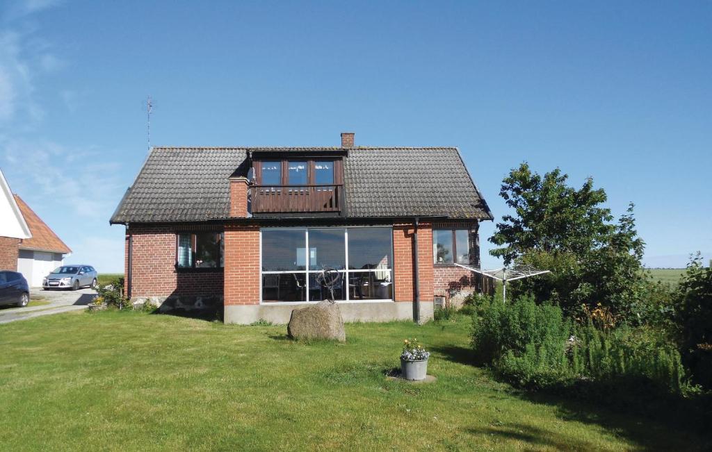a brick house with a large window in a yard at Nice Home In Simrishamn With Kitchen in Simrishamn