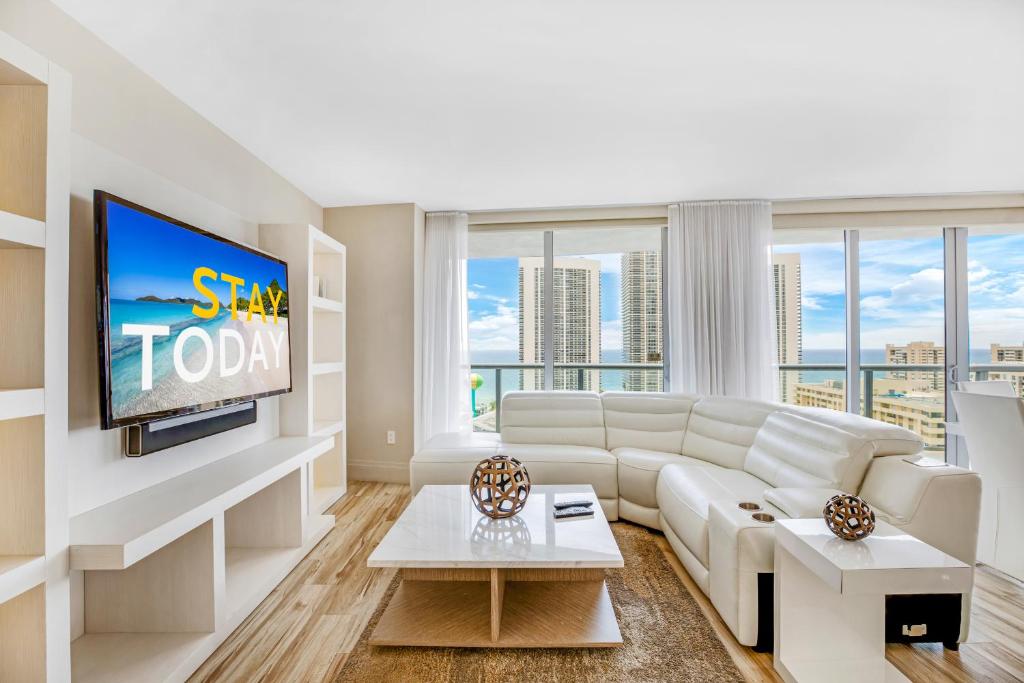 Una sala de estar con un sofá blanco y un televisor. en Beachwalk Resort - BRIGHT OCEAN VIEW CONDO LUXURY 3BDR, en Hallandale Beach