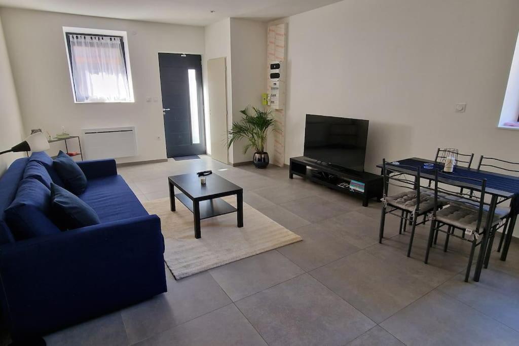 - un salon avec un canapé bleu et une table dans l'établissement Beau Appartement T2, à Saint-Georges-dʼEspéranche