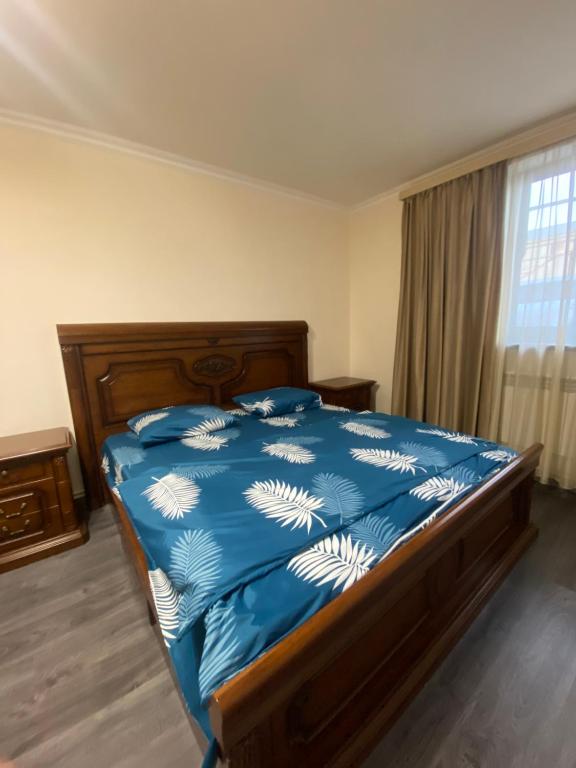 ein Schlafzimmer mit einem Bett mit blauer Decke und einem Fenster in der Unterkunft 3 Cosy apartment near Airport EVN in Yerevan