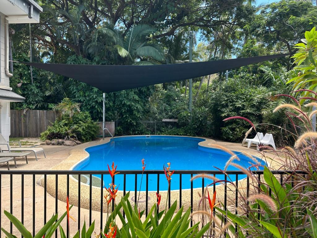 a blue swimming pool with a black umbrella over it at 4 Bedroom House in Arcadia with huge Pool and Wifi 'Brookehaven' in Arcadia