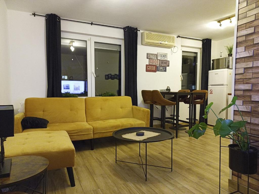 een woonkamer met een gele bank en een tafel bij Skyloft Zagreb in Zagreb