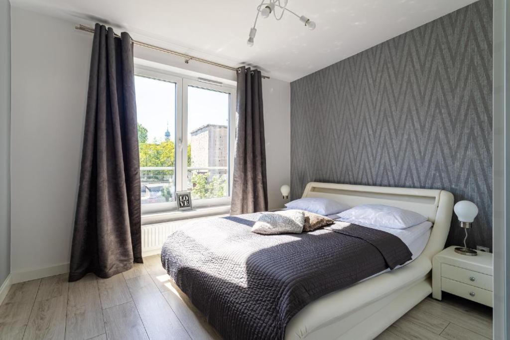 a bedroom with a large bed with a window at Apartament Old Town Tartaczna 43 in Gdańsk