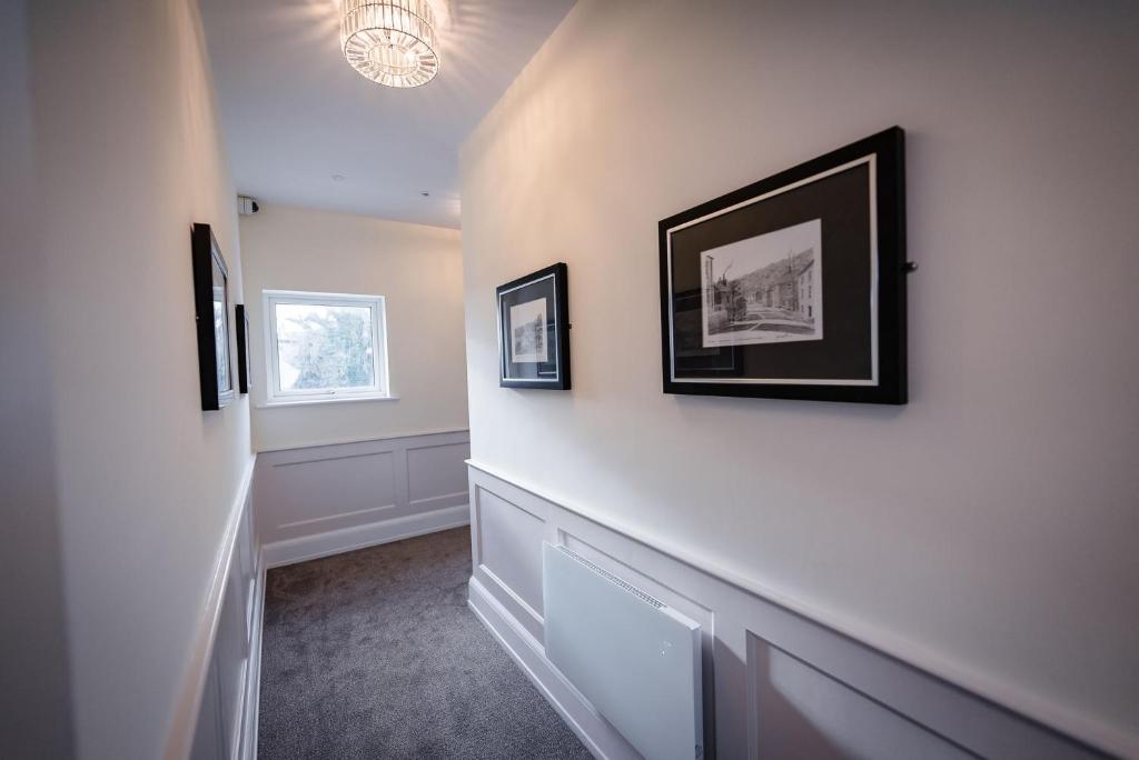 a hallway with two framed pictures on the wall at Shore Hotel Laxey in Laxey