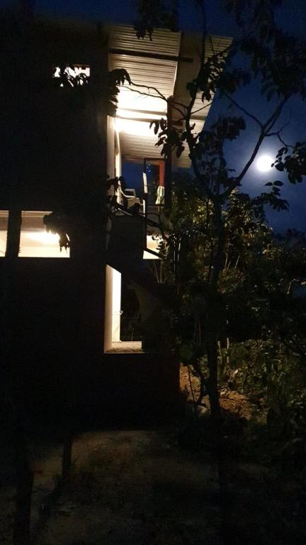 a house at night with the moon in the background at Chales Estrela Veadeiros in Alto Paraíso de Goiás