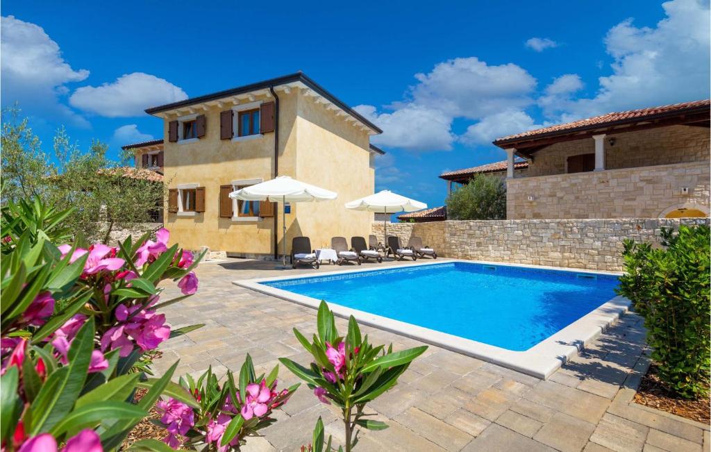 a villa with a swimming pool and a house at Awesome Home In Turcic With 4 Bedrooms, Wifi And Outdoor Swimming Pool in Vantačići