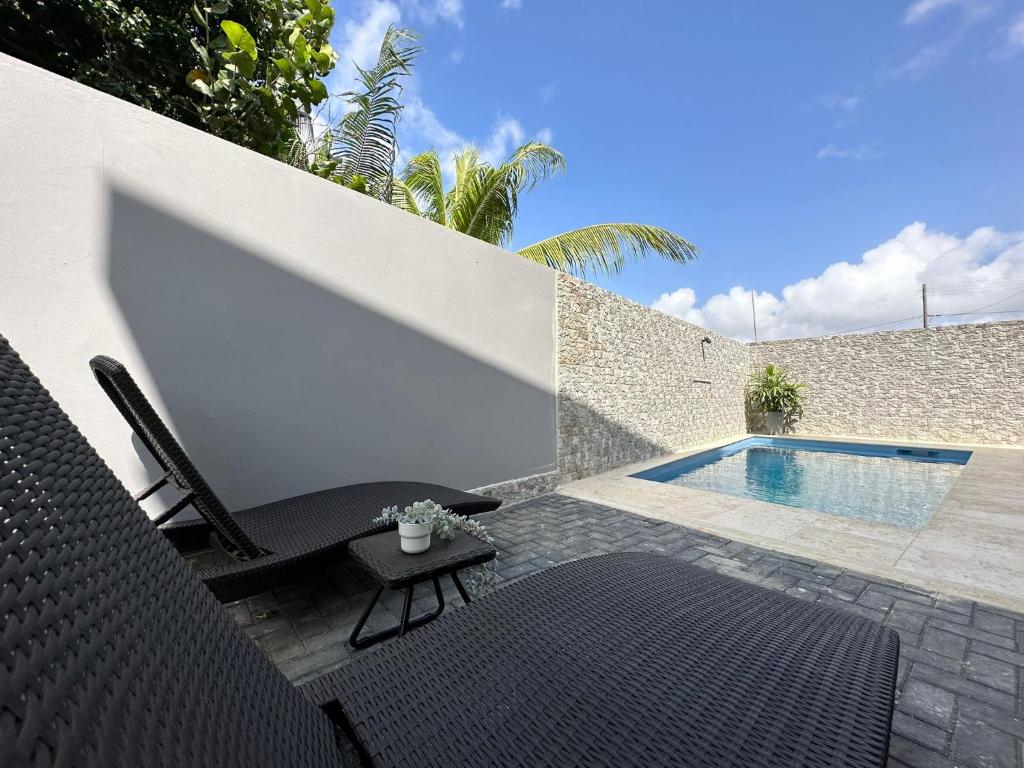 a patio with a chair and a swimming pool at Lirmar Apartments in Kralendijk