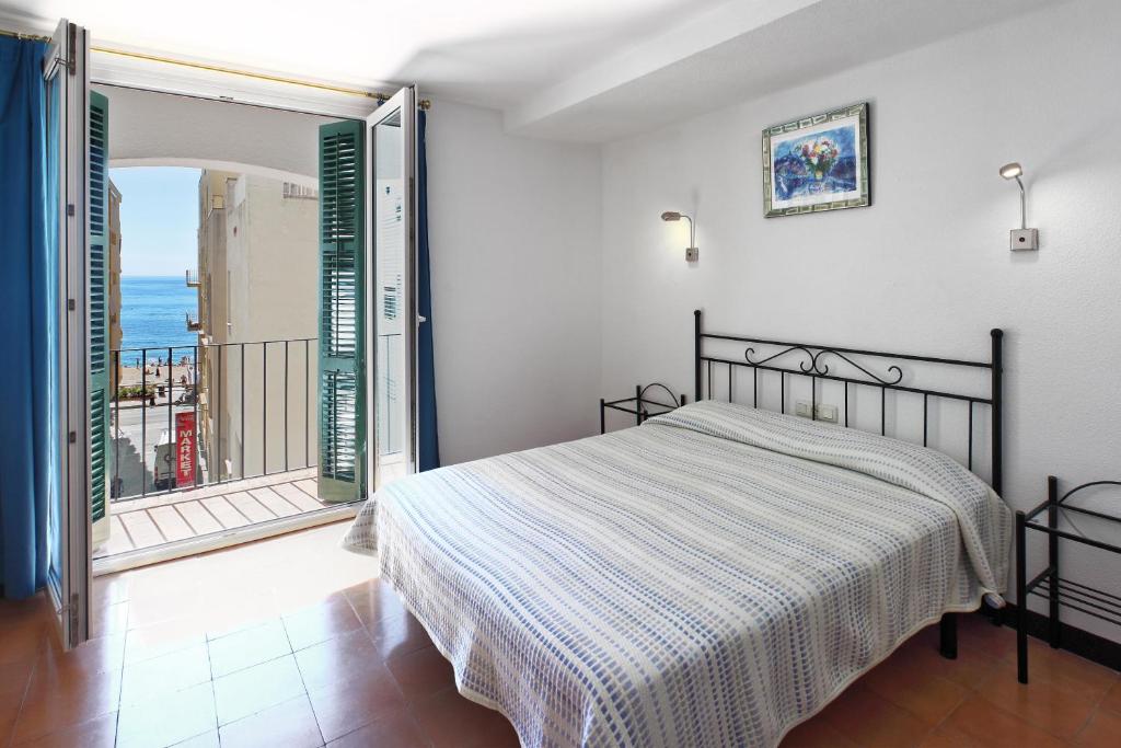 a bedroom with a bed and a balcony at Hotel Caleta in Lloret de Mar