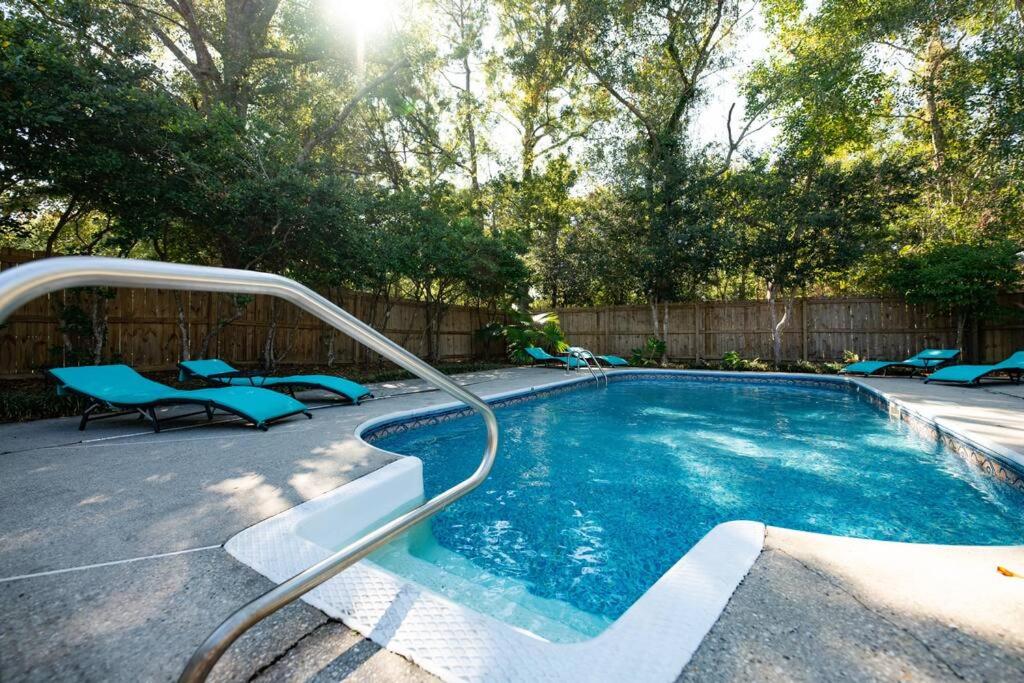 una piscina con sillas azules junto a una valla en Relaxing 5-Bedroom Villa with Outdoor Oasis, en Bay Saint Louis