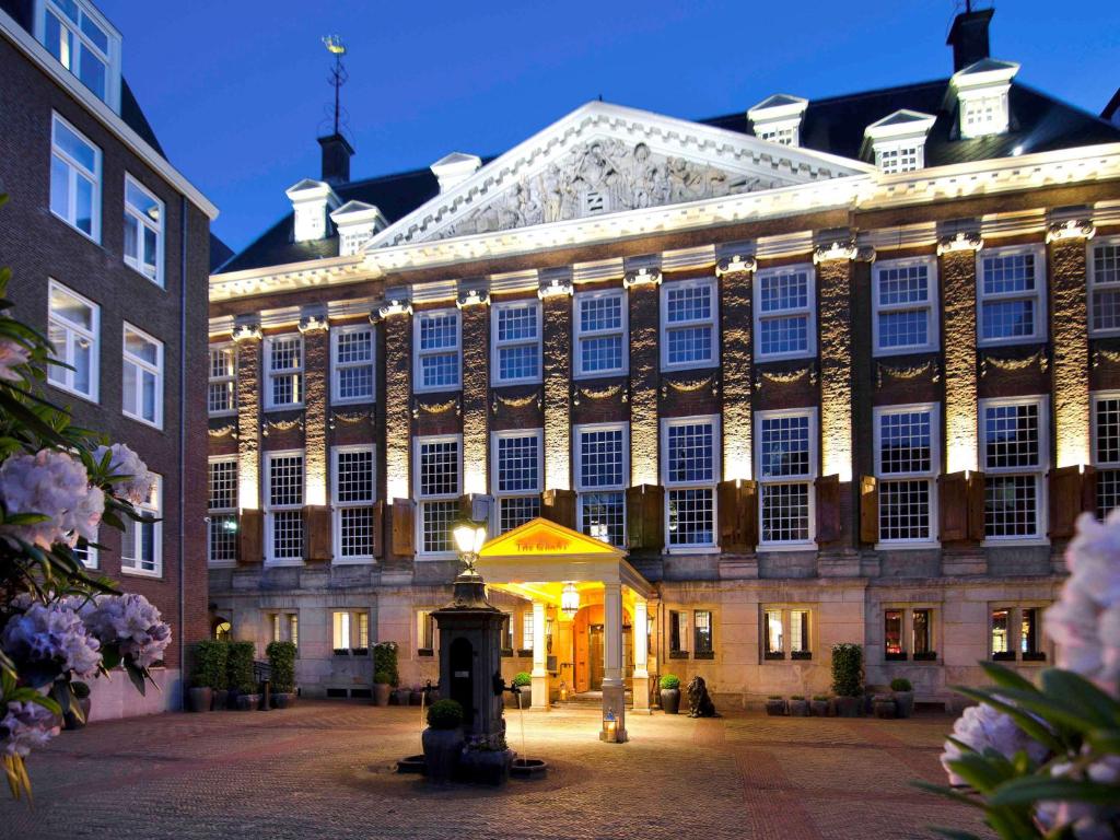 un gran edificio con luces delante en Canal House Suites at Sofitel Legend The Grand Amsterdam, en Ámsterdam