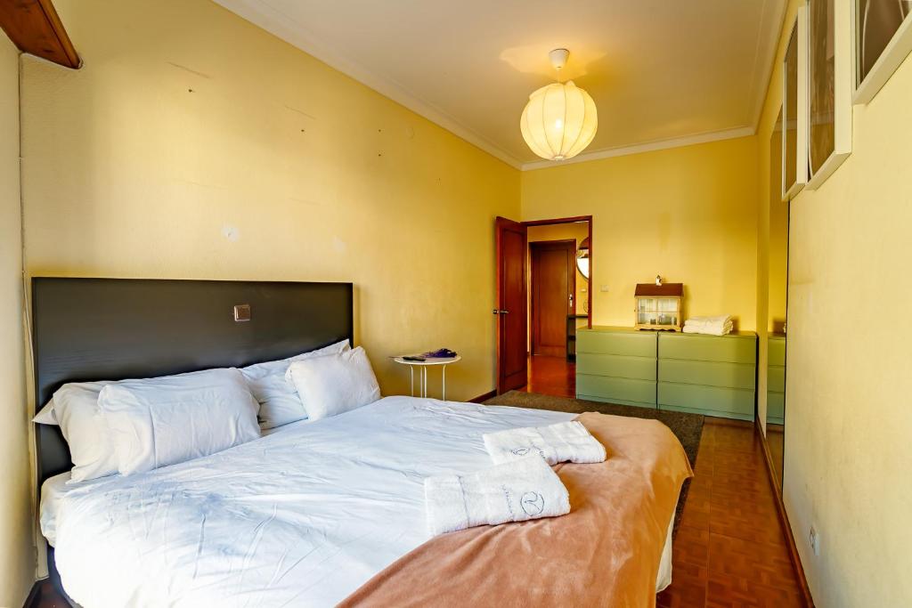 ein Schlafzimmer mit einem großen Bett mit weißer Bettwäsche in der Unterkunft Porto Central Home in Porto