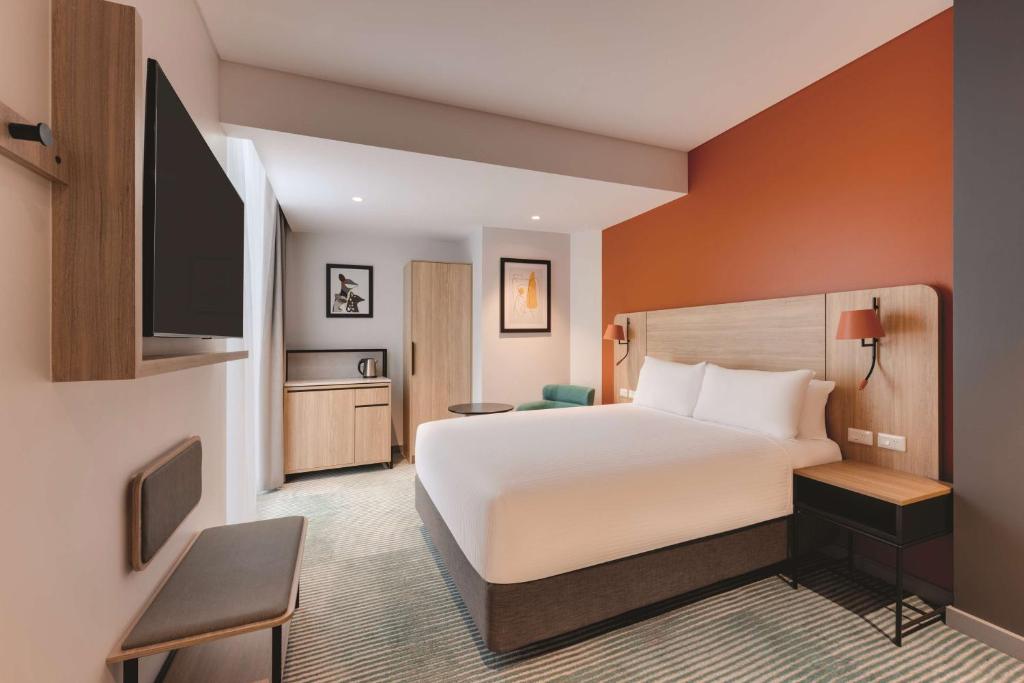 a hotel room with a bed and a flat screen tv at Travelodge Hotel Hurstville Sydney in Sydney