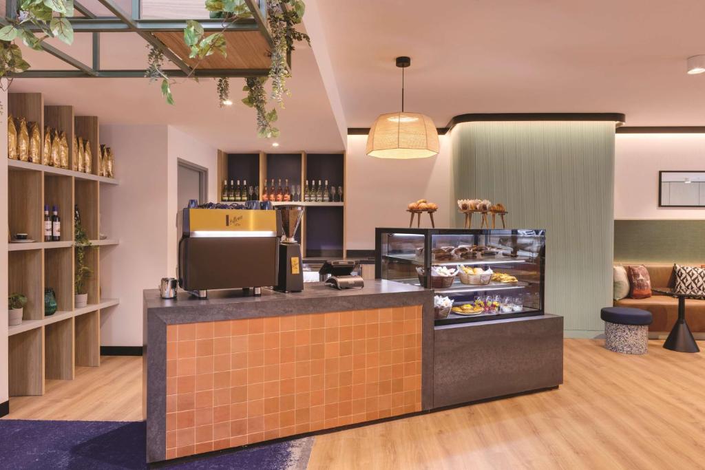 a restaurant with a counter with a display of food at Travelodge Hotel Hurstville Sydney in Sydney