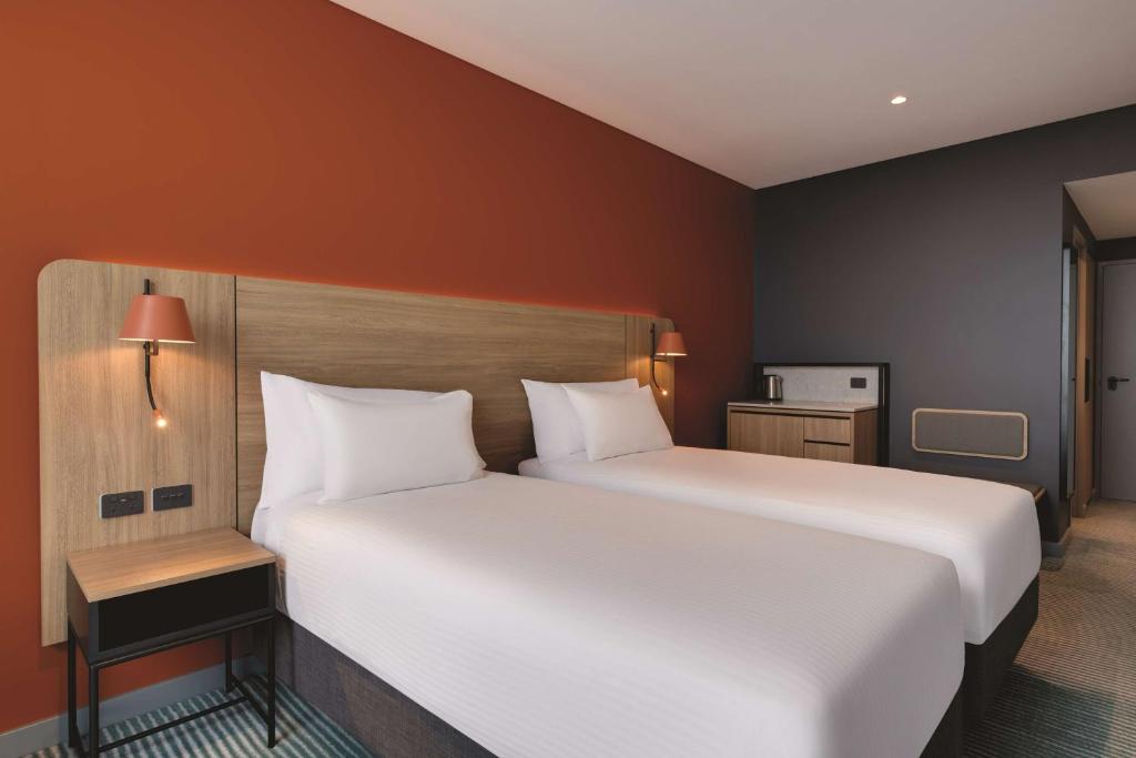 a bedroom with a large white bed in a room at Travelodge Hotel Hurstville Sydney in Sydney