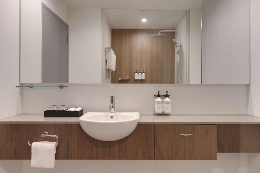 a bathroom with a white sink and a mirror at Travelodge Hotel Hurstville Sydney in Sydney