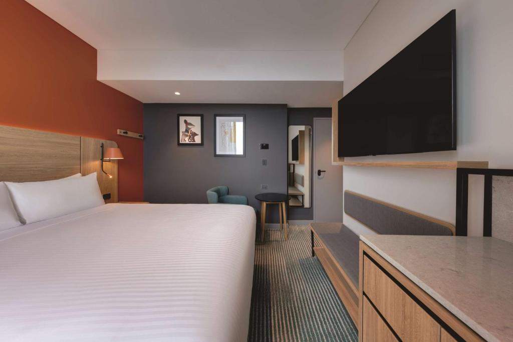a hotel room with a bed and a tv at Travelodge Hotel Hurstville Sydney in Sydney