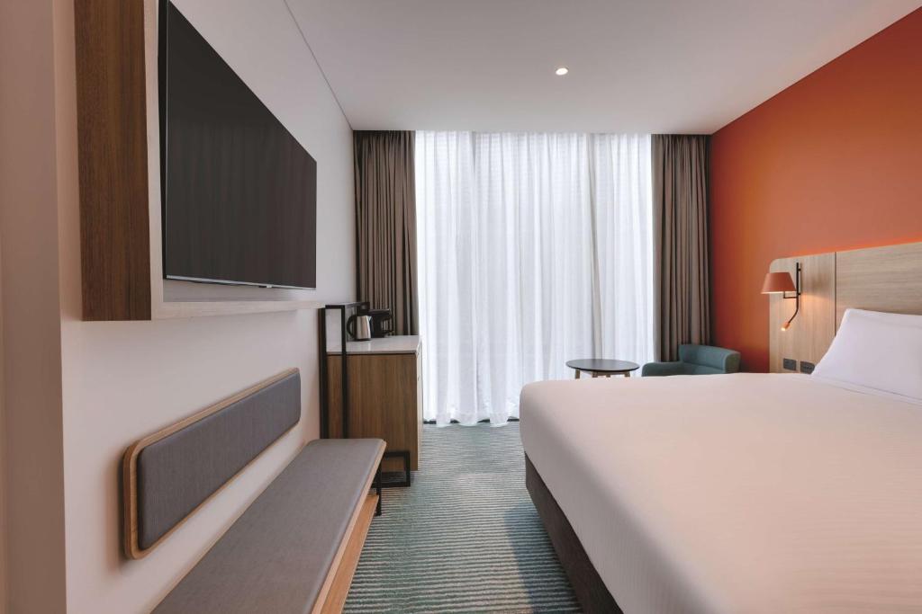 a hotel room with a bed and a tv at Travelodge Hotel Hurstville Sydney in Sydney