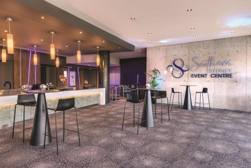 a lobby with tables and chairs and a bar at Travelodge Hotel Hurstville Sydney in Sydney