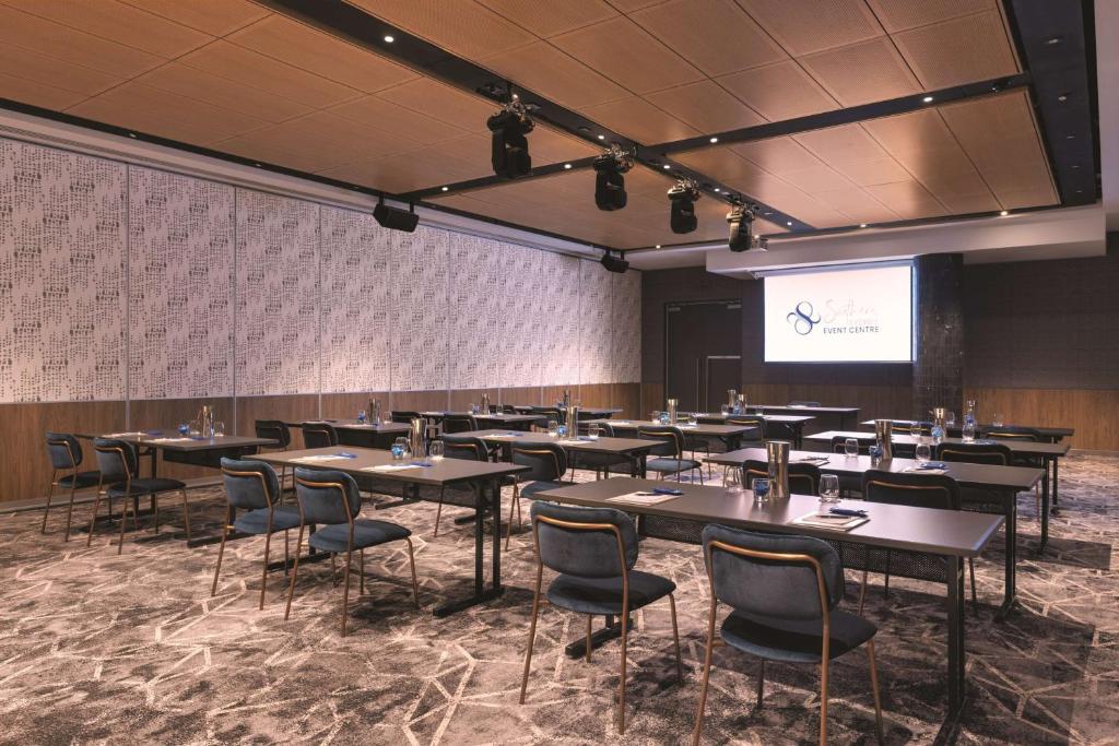 a conference room with tables and chairs and a screen at Travelodge Hotel Hurstville Sydney in Sydney