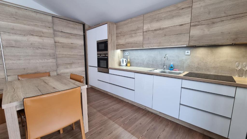 een keuken met witte kasten en een houten vloer bij Appartement Franco in Maria Alm am Steinernen Meer