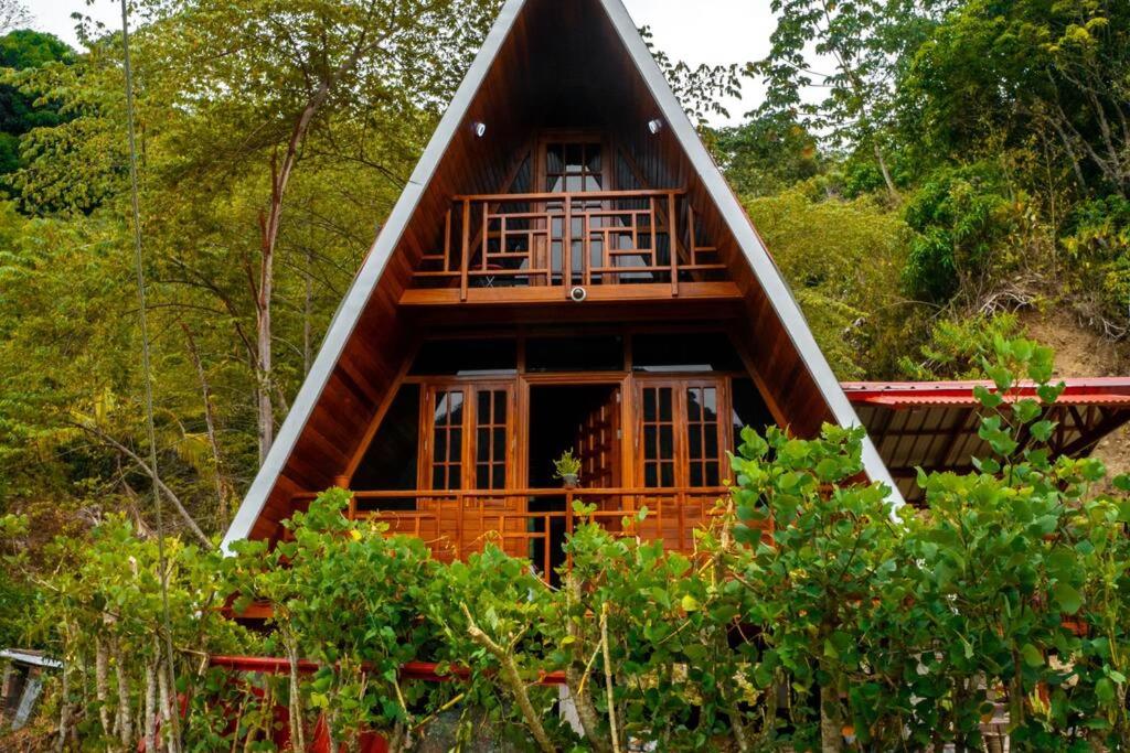 una cabaña en el bosque con techo de paja en Casa Alpina El Emperador - Chanchamayo, en La Merced