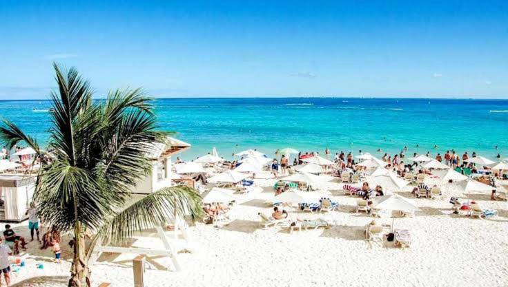 a group of people on a beach with the ocean at Hotel Castillo Del Mar - 5 Th Ave in Playa del Carmen