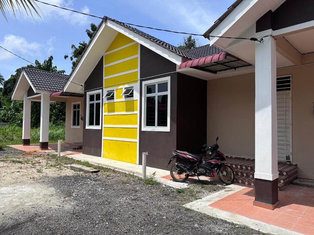 une moto garée devant une maison dans l'établissement Homestay Mama, Kota Bharu, à Kota Bharu