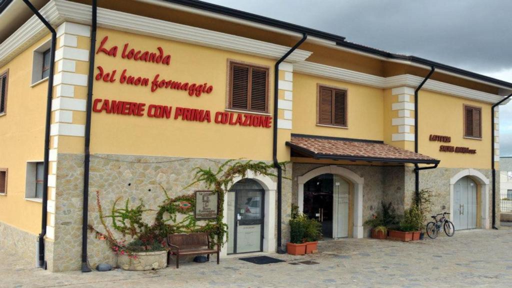 un bâtiment avec un panneau sur son côté dans l'établissement La Locanda del Buon Formaggio, à Tito