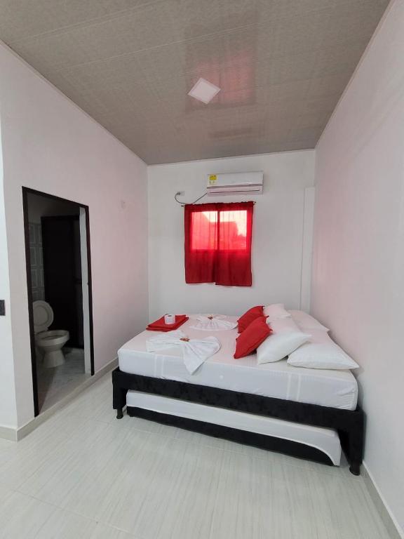 a bedroom with a bed with a red window at ALOJAMIENTOS GLORIA in Doradal