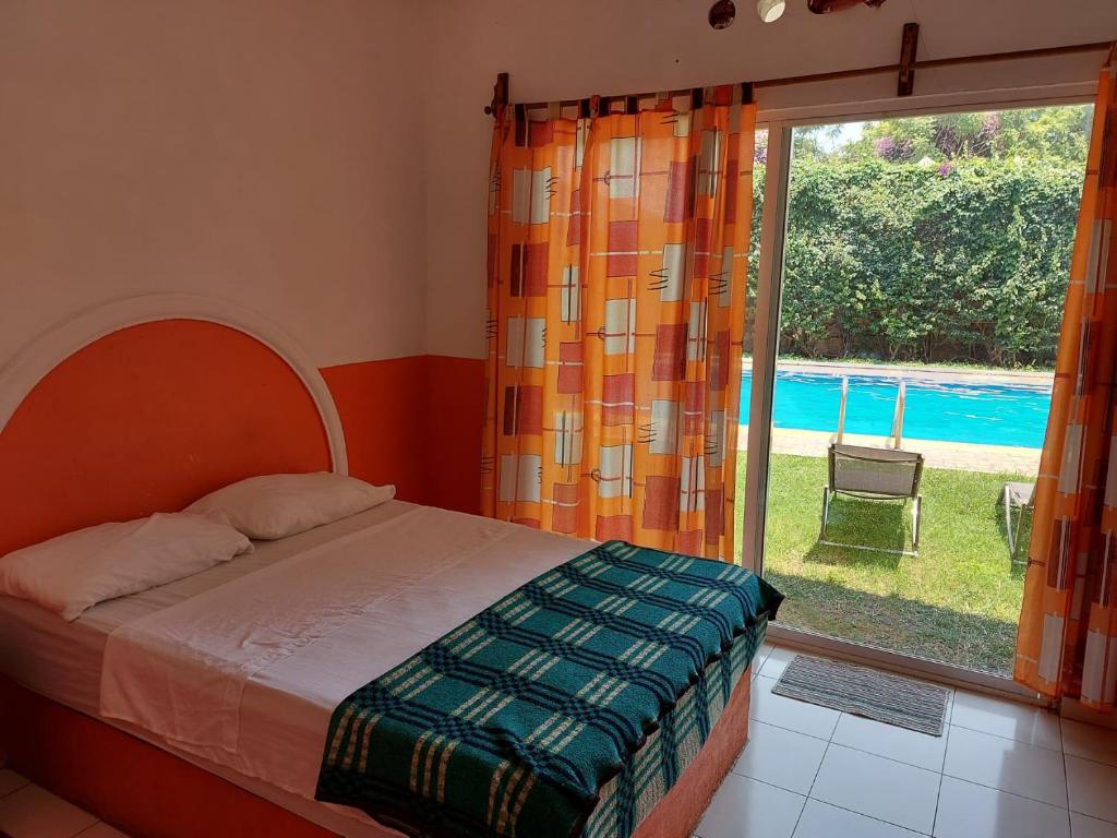 a bedroom with a bed and a large window at Palmas in Cuernavaca
