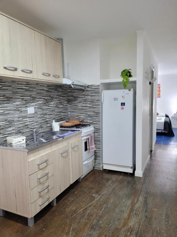 a kitchen with a white refrigerator and a sink at Departamento Desire in Puerto Deseado