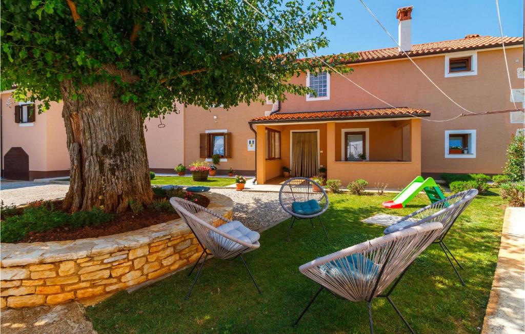 a yard with two chairs and a tree at 3 Bedroom Cozy Home In Svetvincenat in Svetvinčenat
