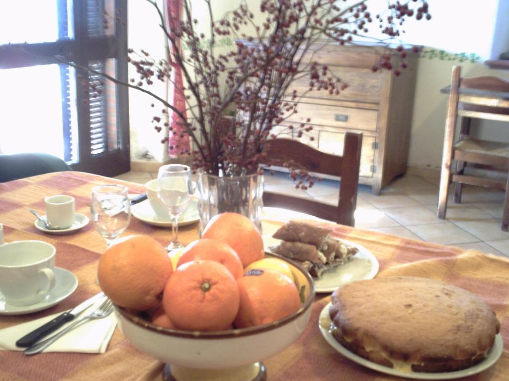 a table with a bowl of oranges on a table at Agriturismo il Mercante in San Martino