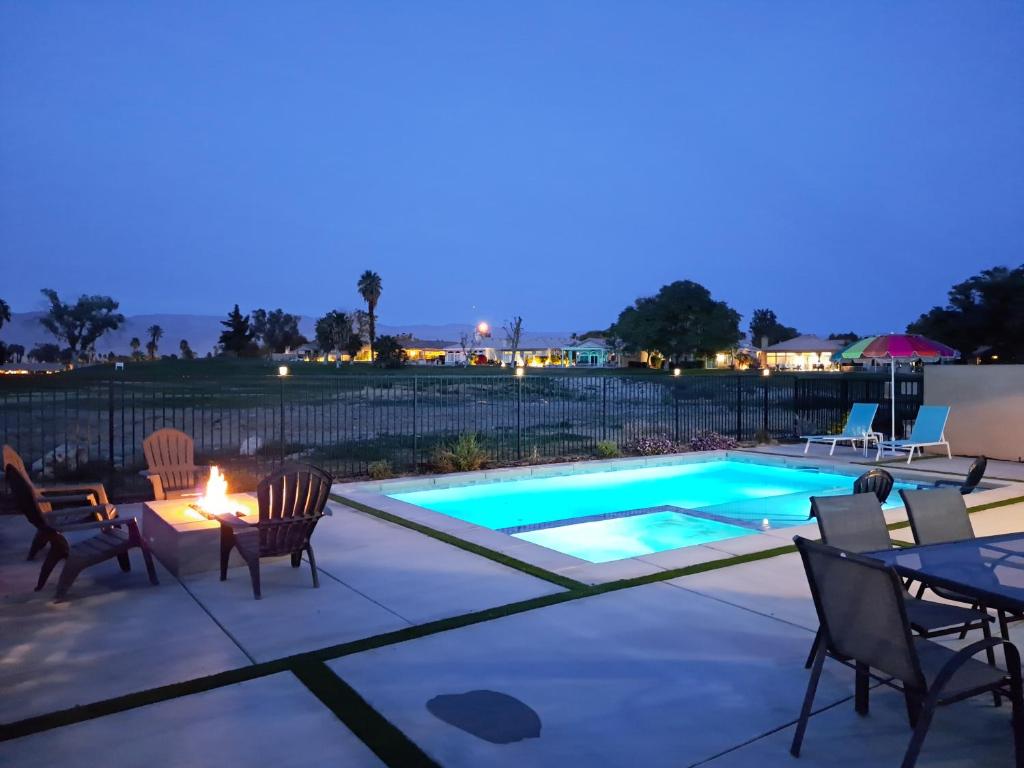 a patio with a pool and chairs and a table at Luxury Oasis, Stunning View, Private Pool, BBQ, Firepit, Gated, Walk to Music Festival in Indio