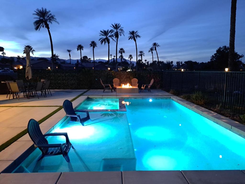 a swimming pool with two chairs and a table at Desert Escape, Stunning View, Pool, BBQ, Firepit, Gated, Walk2 Coachella Music Festival in Indio