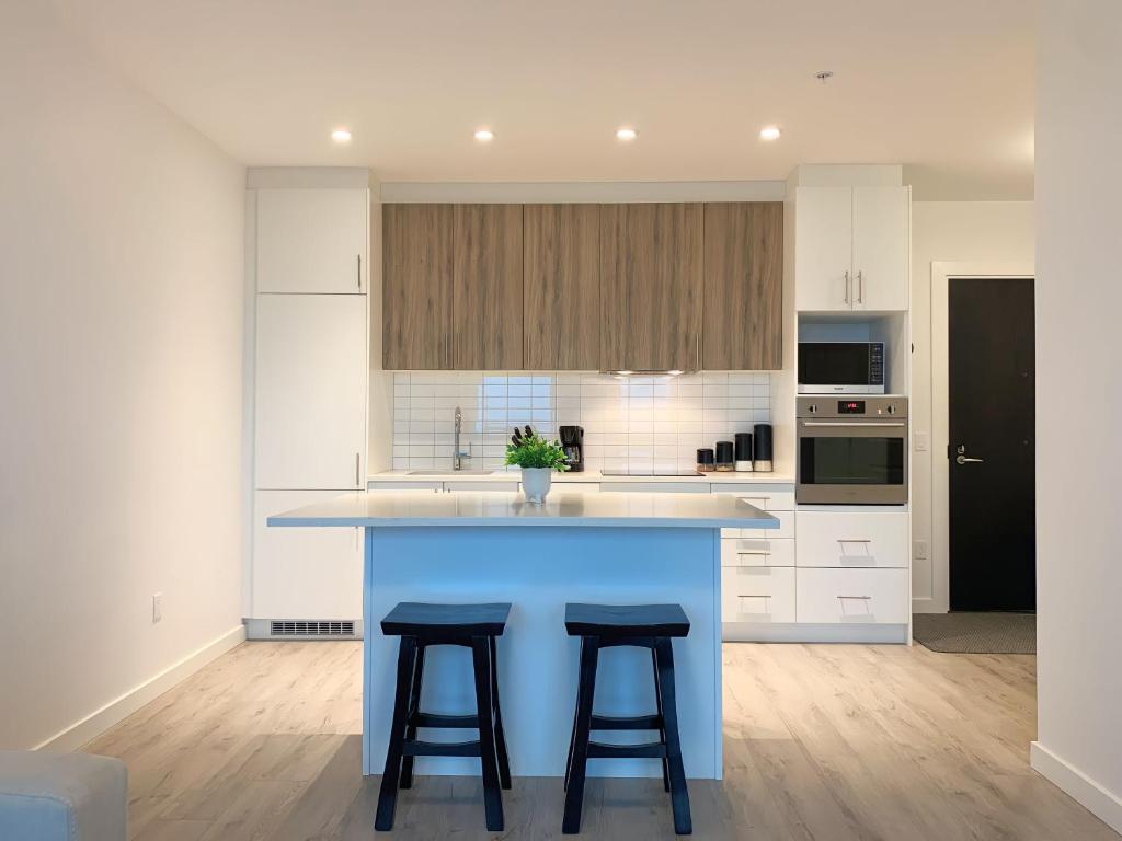 a kitchen with a blue island with two bar stools at Cozy 1BR Condo w/ Insuite LDRY, Gym & Free Parking in Waterloo
