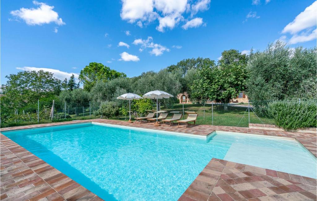 una piscina con sedie e ombrelloni in un cortile di Villa Dei Girasoli a Petriolo