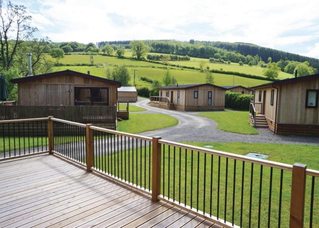 a deck with a view of a group of cabins at Clun Valley Lodges in Clunton