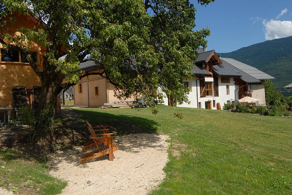 a wooden bench sitting under a tree in front of a house at Le Gite de Noemie in Mercury