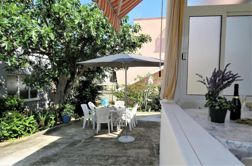 a table and chairs with an umbrella on a patio at House Franica in Zadar