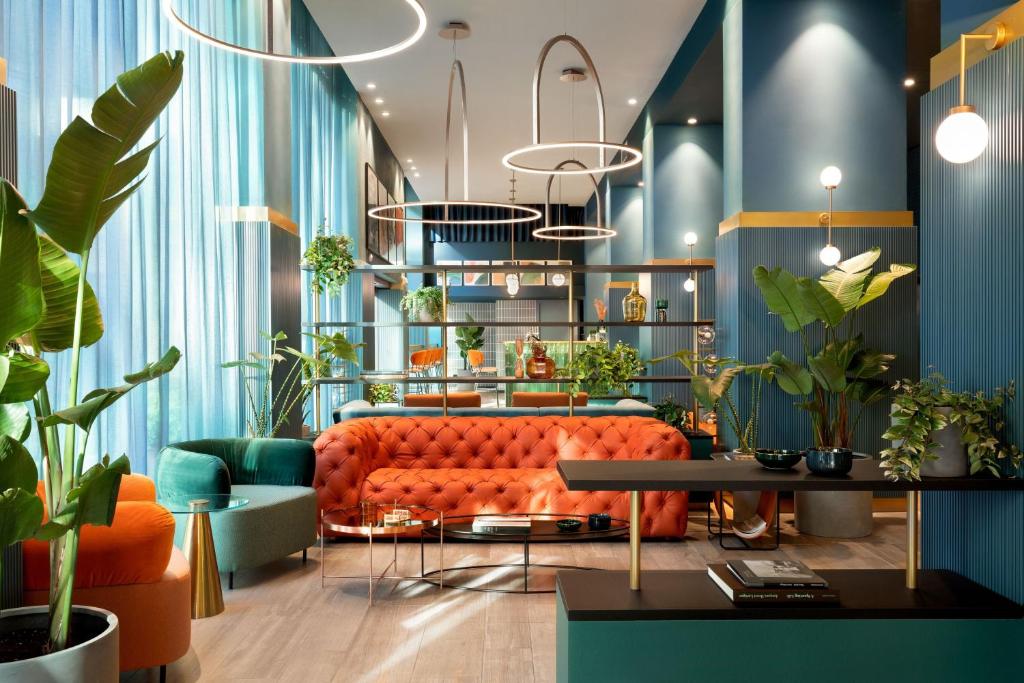 uma sala de estar com um sofá laranja e plantas em Duo Milan Porta Nuova, a Tribute Portfolio Hotel em Milão