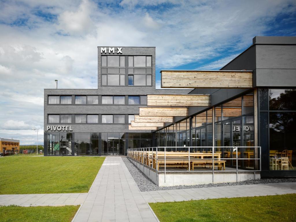 a large building with benches in front of it at Pivotel MMX in Dobřichovice