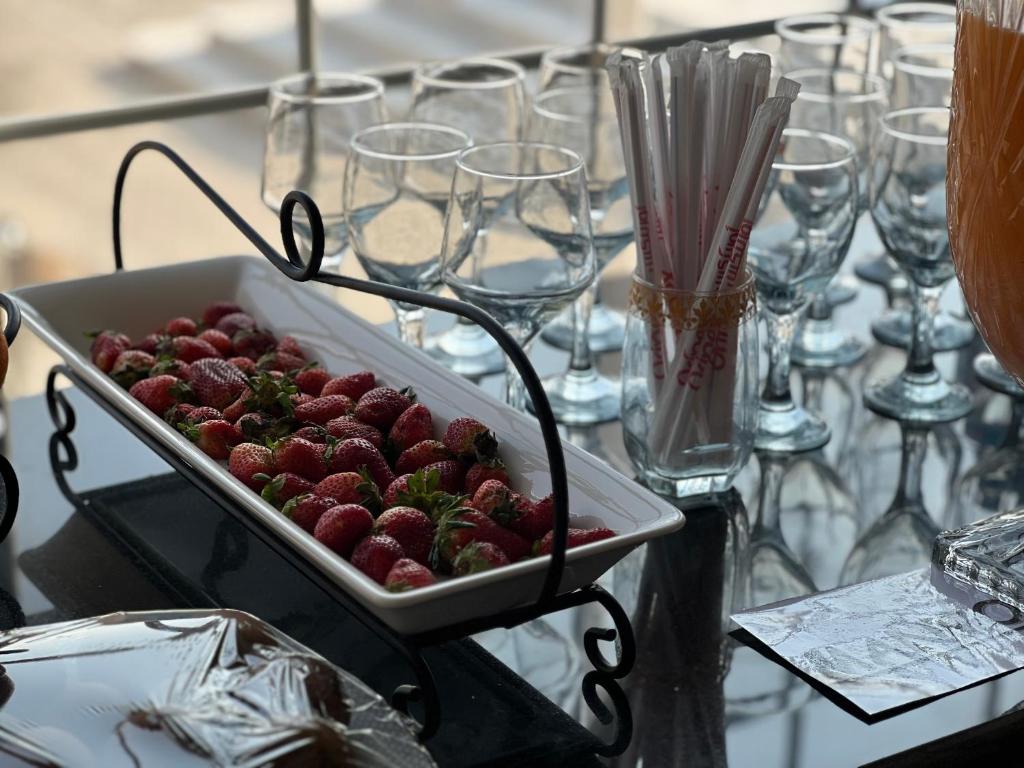 a tray of strawberries on a table with glasses at Hotel Hayatt Sukkur in Kalar Goth
