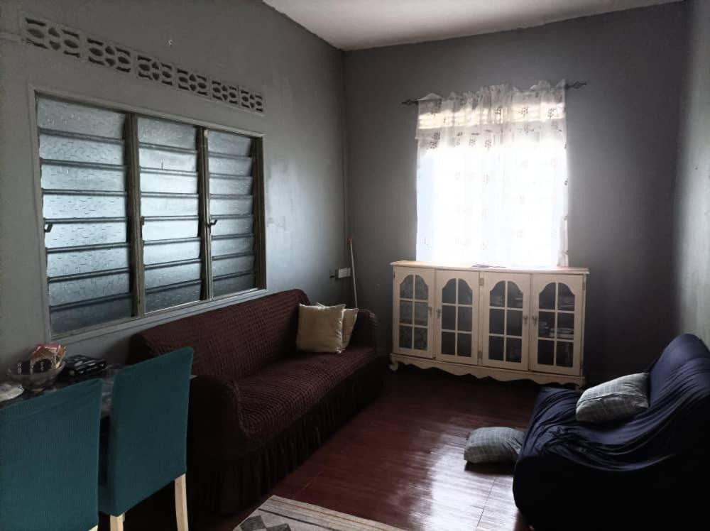 a living room with a couch and a window at Miezzan Homestay in Kuala Selangor