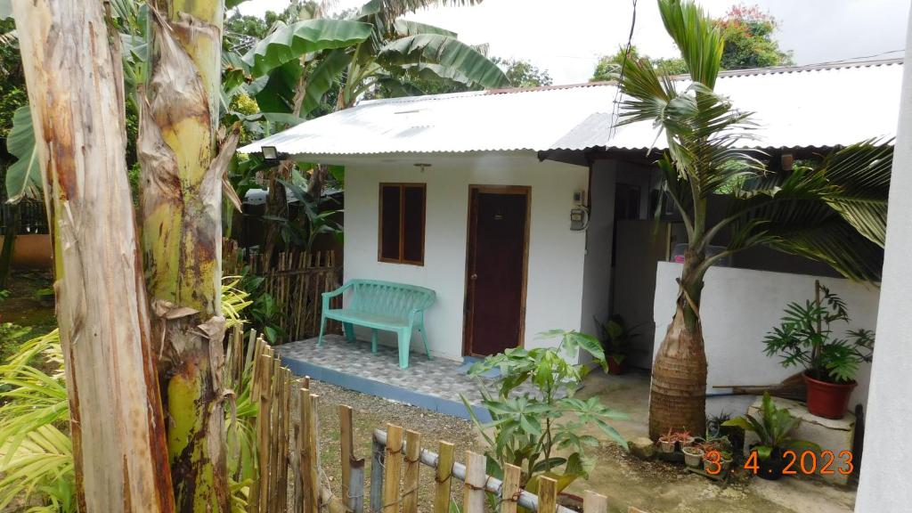 una pequeña casa con un banco verde delante de ella en Cute Quiet Private Room w own Kitchen, CR, Porch, en Panglao