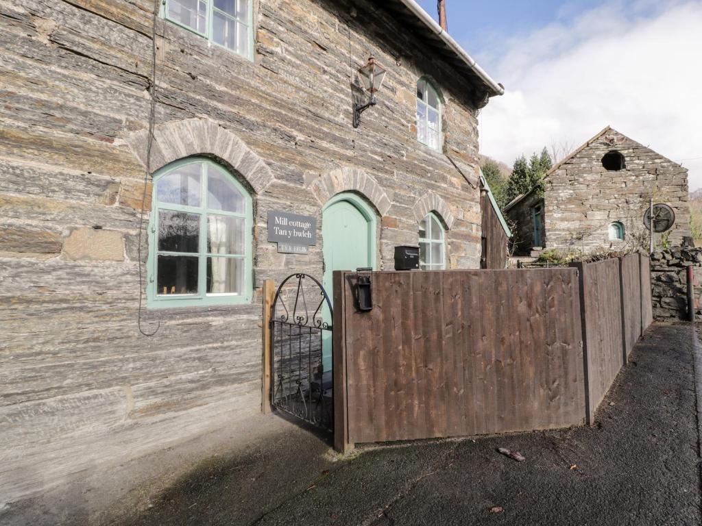 a wooden gate in front of a building at Mill Cottage in Blaenau-Ffestiniog